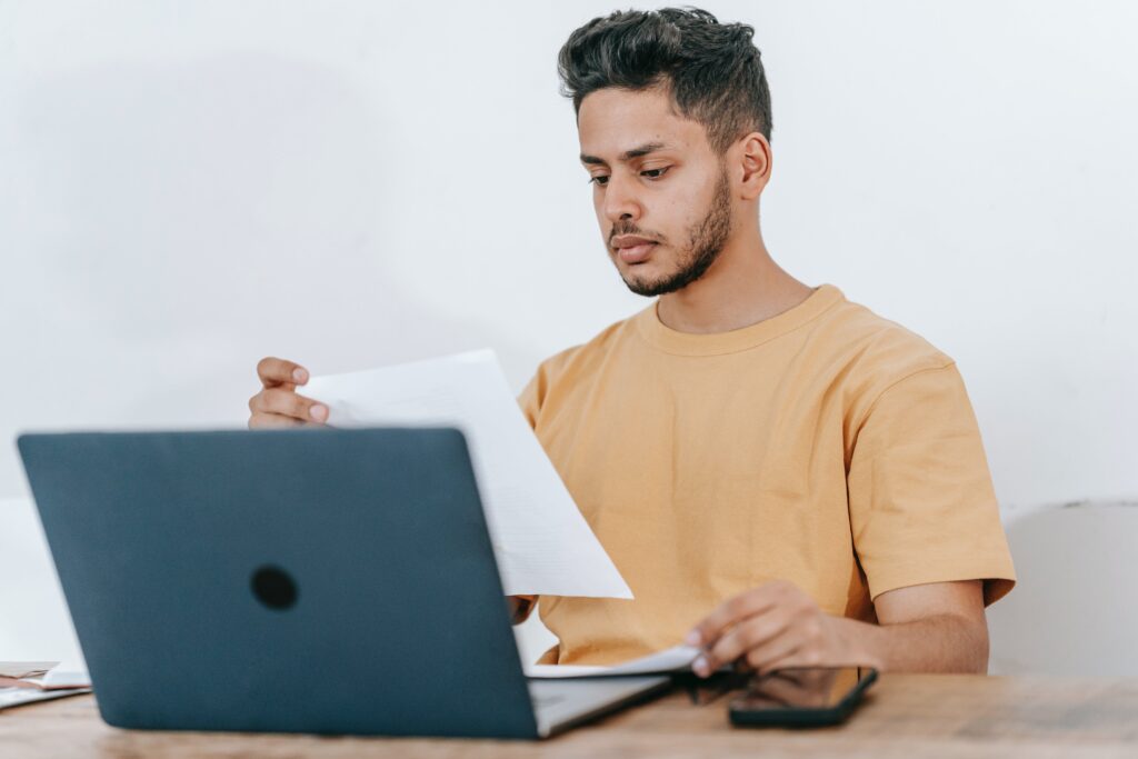 Man reviewing 3PL paper with laptop